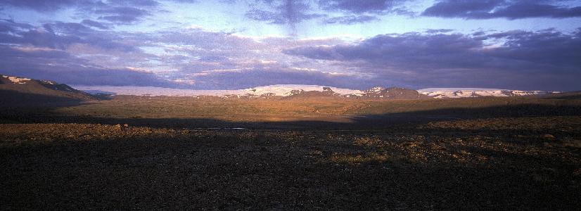 Myndin sýnir sandflæmi með fjallgarða í fjarska